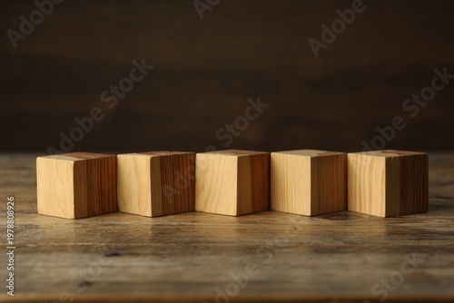Blank cubes on wooden table, space for text