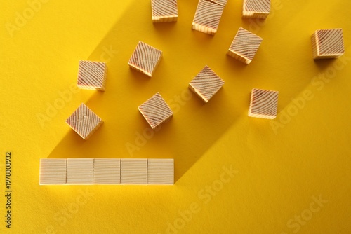 Many blank wooden cubes on yellow background, flat lay. Space for text