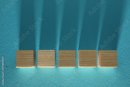 Blank wooden cubes on turquoise background, flat lay. Space for text