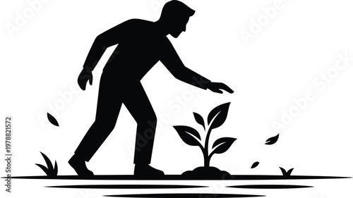 Silhouette of a person tending to a small green plant growing from the earth with leaves scattered