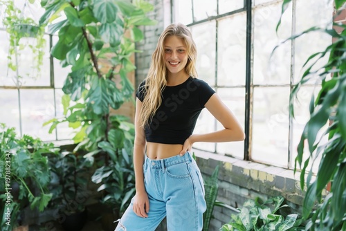 Model Poses in a Sunny Indoor Garden With Green Plants and Bright Windows