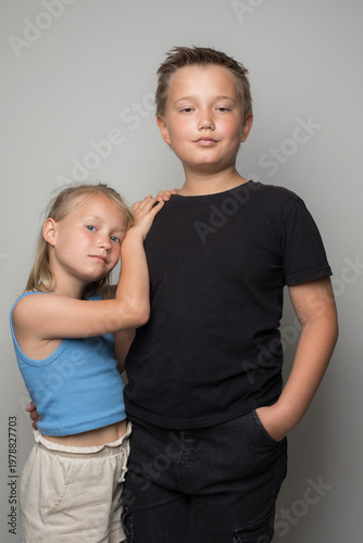 Happy successful sibling. Little sister and brother together. Cute girl and boy standing posing