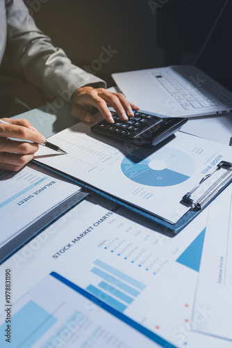 business people or accountant using calculator while working analytical business report on the workplace, accounting concept, Serious and focused financier accountant on paper work inside office,