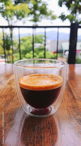 Freshly Brewed Coffee Served in a Clear Glass on a Wooden Table With Trees in...