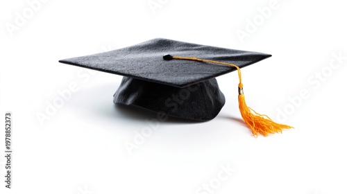 Black Graduation Cap With Yellow Tassel Hanging on a White Wall During a Grad...