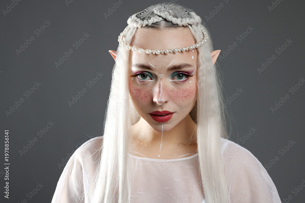 Naklejka premium Beautiful girl dressed as elf on grey background