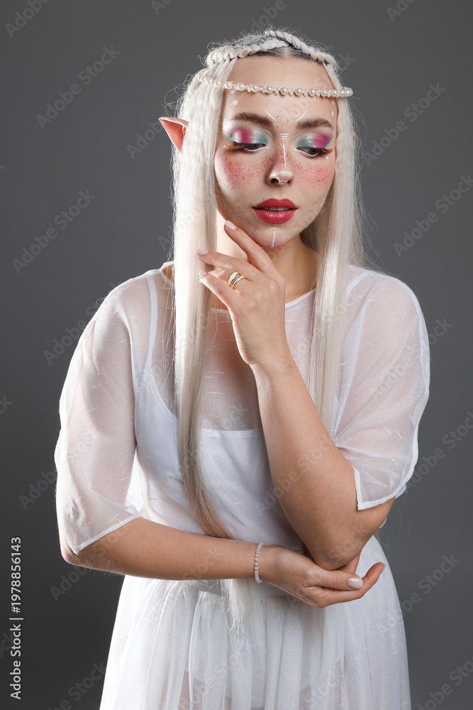 Naklejka premium Beautiful girl dressed as elf on grey background