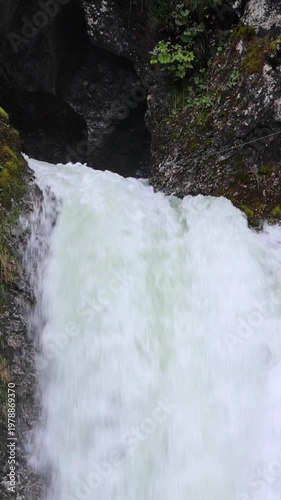 beautiful scenic small waterfall in forest next to farm river and bike trail in bohinj slovenia europe (stunning landscape julian alps alpine mountains scenery) trees woods hiking hike path trail