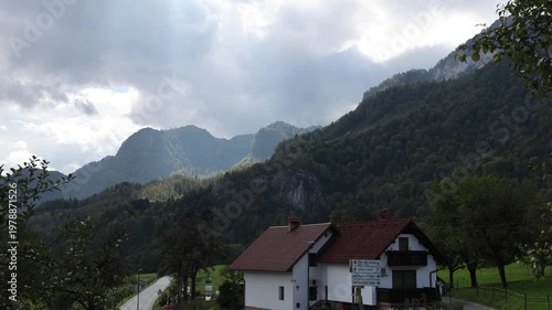 scenic village with houses on small country road with julian alps mountains in the background in bled slovenia