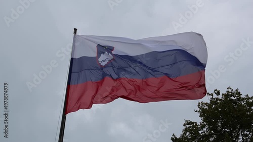 slovenia flag waving in the breeze wind at castle (lake bled) famous travel tourism destination in julian alps