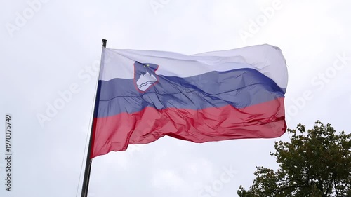 slovenia flag waving in the breeze wind at castle (lake bled) famous travel tourism destination in julian alps
