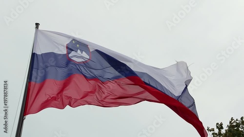 slovenia flag waving in the breeze wind at castle (lake bled) famous travel tourism destination in julian alps