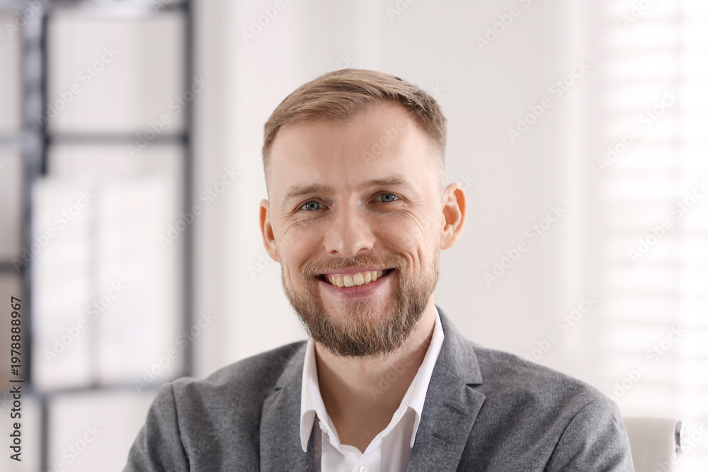 Naklejka premium Portrait of smiling businessman in suit in office