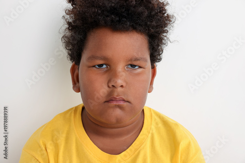 Canvas Print Portrait of resentful little boy on light grey background