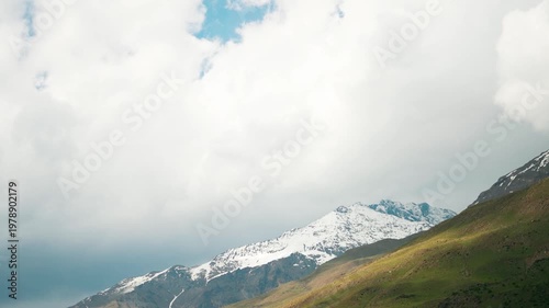4k Landscape shot of snowy Himalayan mountain peaks with clouds above them during the sunset in summer season as seen from Tandi village in Lahaul and Spiti district, Himachal Pradesh, India. 