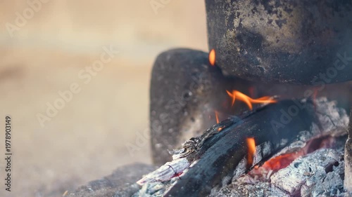 4K Closeup shot of wood burning in a traditional wood stove for preparation of food in rural India as seen in the villages of Gujarat, India. Food being prepared by burning wood in stove.