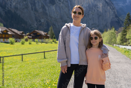 Traveling young woman with child visiting beautiful village in Lauterbrunnen. 