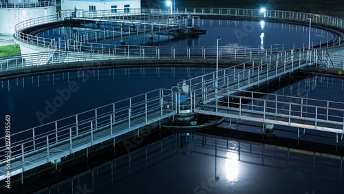 Moonlit Wastewater Treatment Basins with Reflective Dark Surfaces Create a Surreal Industrial Landscape After Hours