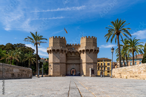 Torres de serranos stands as a medieval gothic gate with palm trees and a bridge