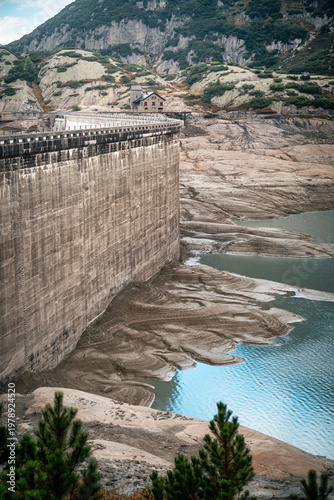 Gelmersee dam rises above low reservoir levels in Swiss Alps, ideal for climate change concepts
