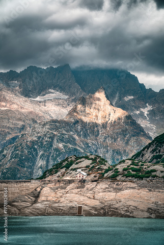 Gelmersee dam rises above low reservoir levels in Swiss Alps, ideal for climate change concepts