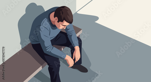 A man sitting on a bench looking down.