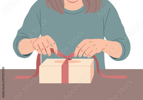 A woman carefully ties ribbon around a gift box, showcasing elegant pastry packaging. Soft colors and a focused expression create a warm, inviting scene.