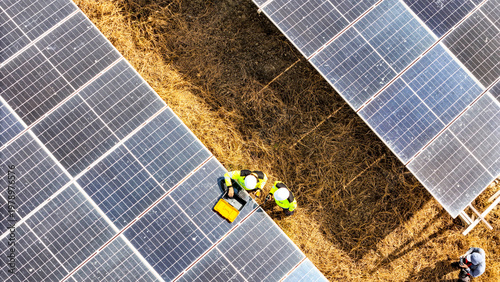 Foto Top down drone shot of professional workers checking photovoltaic modules