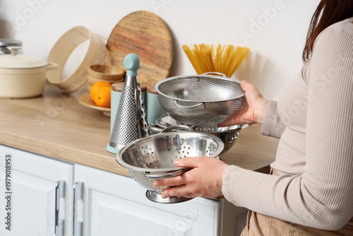 Woman with metal colanders ...