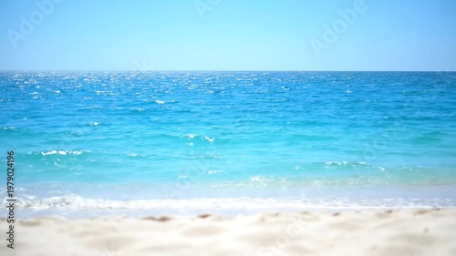 Serene ocean waves on sandy beach.