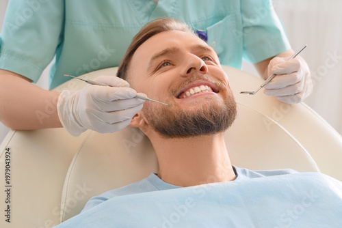 Young man visiting dentist on couch in clinic, closeup