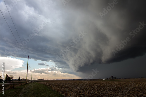 A thick shelf cloud looms in the sky as a storm approaches.