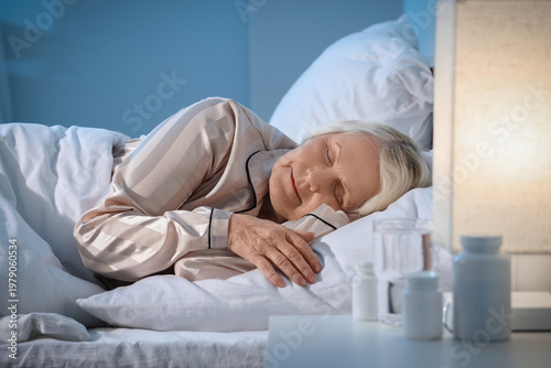 Senior woman sleeping in be...