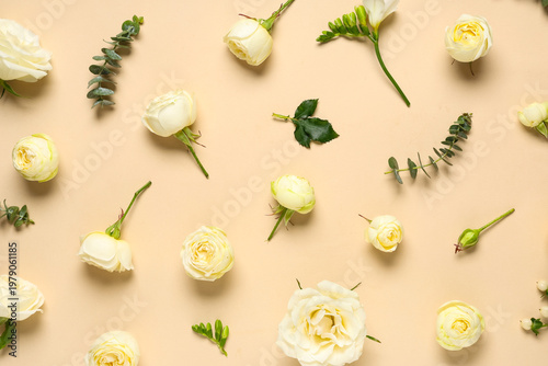 Composition with white rose flowers and green leaves on beige background