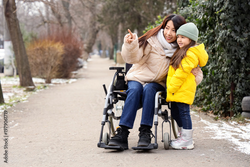 Young Asian mother in wheel...