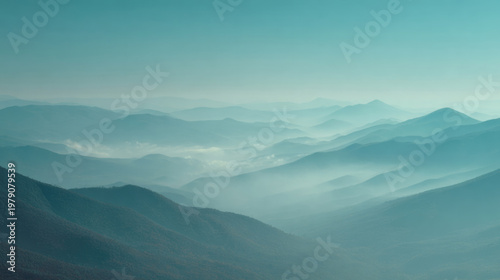 Serene Misty Mountain Landscape with Layered Blue Peaks and Morning Fog