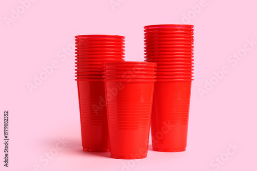 Red plastic cups on pink ba...