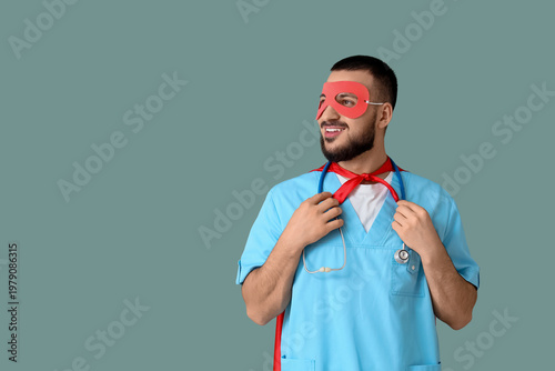 Male doctor dressed as superhero on green background