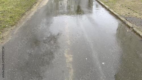 On a cloudy day, it rains on the road in an urban area, and rainwater accumulates
