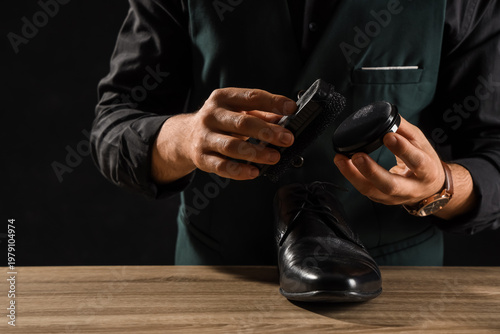 Male shoemaker polishing sh...