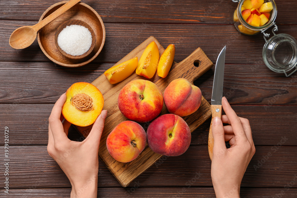 Obraz premium Woman preparing sweet peach jam on wooden background