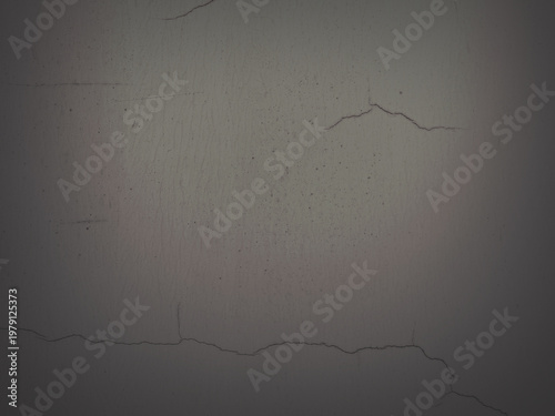 Texture of the old wall. Rough grungy surface of painted plastered concrete wall with spots, cracks, noise and grain. Faded dark gray background for design. Shaded vintage texture with vignette.