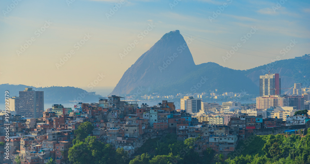Fototapeta premium Iconic Sugarloaf Mountain rising above Rio de Janeiro favelas and urban skyline with copy space