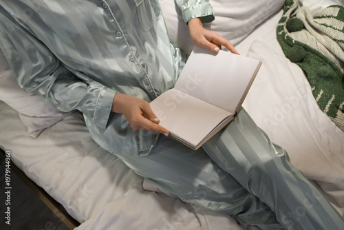 Young woman reading book on...
