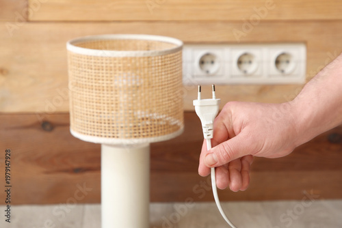 Male hand with plug near so...