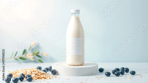 Fresh white milk in a bottle on a white podium with blueberries scattered around the bottle