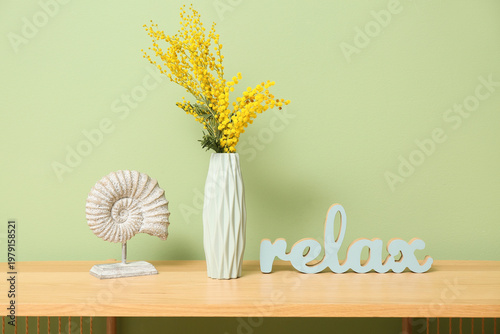 Vase with mimosa flowers an...