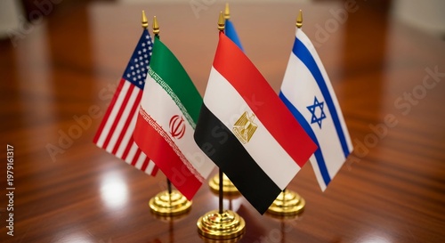 Flags of the United States, Iran, Egypt, and Israel stand together on a polished wooden table