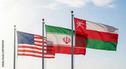 Three national flags waving in the wind against a clear blue sky