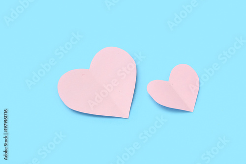 Pink paper heart on blue background. Valentine's Day celebration